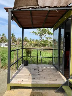 a porch of a house with a potted plant on it at Hostal pura vida in San Bernardo del Viento
