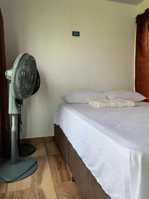 a bedroom with a fan next to a bed at Hostal pura vida in San Bernardo del Viento
