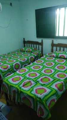 a bedroom with two beds with a green and pink blanket at Tundsya in San Antero