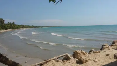 a sandy beach with waves in the ocean at Tundsya in San Antero