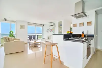 a kitchen and living room with a counter and chairs at Extraordinario!! Salida Directa Playa Sonesta Cartagena Morros in Cartagena de Indias