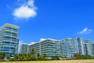 a large building with palm trees in front of it at Extraordinario!! Salida Directa Playa Sonesta Cartagena Morros in Cartagena de Indias