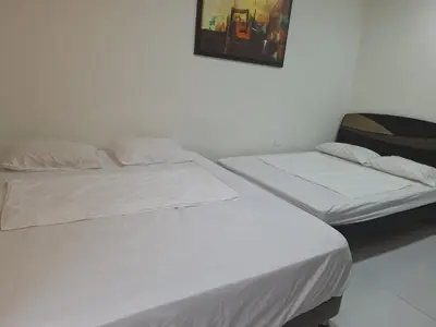 two beds sitting next to each other in a room at Amplia habitación independiente a 2 cuadras de la playa y el aeropuerto in Cartagena de Indias