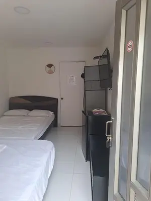 a small room with two beds and a door at Amplia habitación independiente a 2 cuadras de la playa y el aeropuerto in Cartagena de Indias