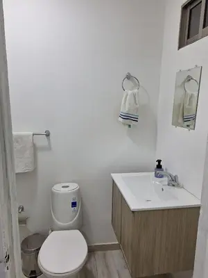 a white bathroom with a toilet and a sink at Amplia habitación independiente a 2 cuadras de la playa y el aeropuerto in Cartagena de Indias