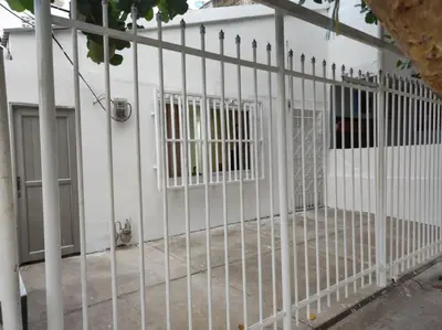a white fence in front of a white building at Amplia habitación independiente a 2 cuadras de la playa y el aeropuerto in Cartagena de Indias