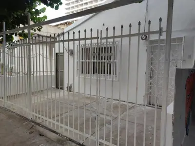 a gate in front of a white building at Amplia habitación independiente a 2 cuadras de la playa y el aeropuerto in Cartagena de Indias