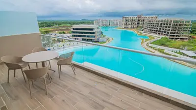 a balcony with a table and chairs and a view of the water at New And Luxury Apartment 3BR In Baia Kristal in Los Arrayanes