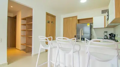 a kitchen with white chairs and a refrigerator at New And Luxury Apartment 3BR In Baia Kristal in Los Arrayanes