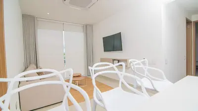 a white room with white chairs and a tv at New And Luxury Apartment 3BR In Baia Kristal in Los Arrayanes