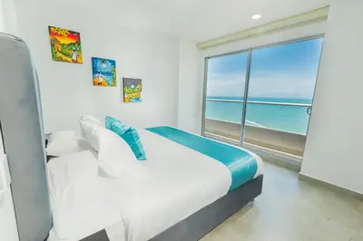 a bedroom with a bed with a view of the ocean at Apto 1417 condominio Santa marina, Santa Marta in Estación El Salto