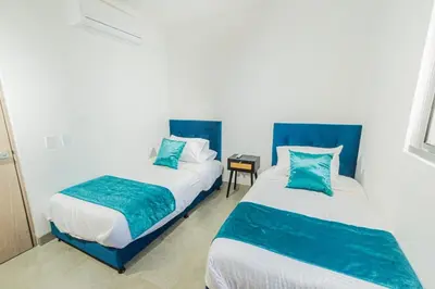 two beds in a room with blue and white at Apto 1417 condominio Santa marina, Santa Marta in Estación El Salto