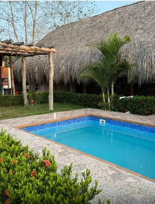 a swimming pool in front of a resort at El Refugio Natural in Turbaco