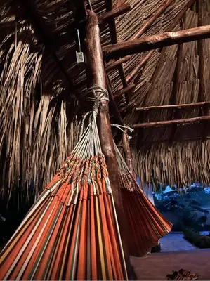 a hammock hanging from a thatched roof at El Refugio Natural in Turbaco