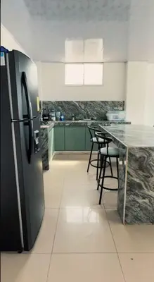 a kitchen with a refrigerator and a table with chairs at Cabaña Eterno Nirvana in Santa Veronica