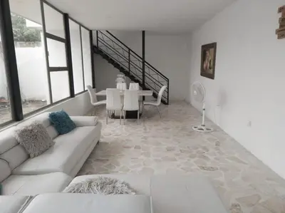 a living room with a white couch and a table at Finca Villa Gabriela