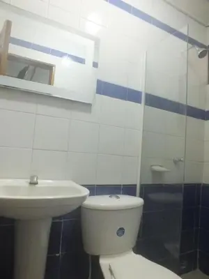 a bathroom with a white toilet and a sink at Hotel Nuevo Horizonte in Barranquilla