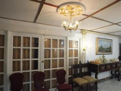 a room with a table and chairs and a chandelier at Hotel Nuevo Horizonte in Barranquilla