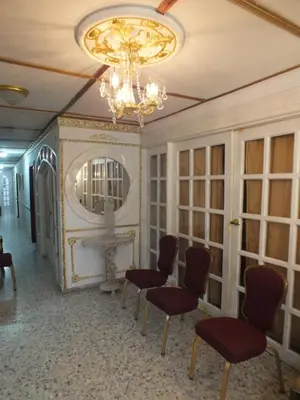 a room with chairs and a mirror and a chandelier at Hotel Nuevo Horizonte in Barranquilla