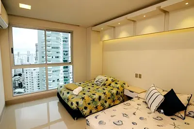 a bedroom with two beds and a large window at Beachfront Bocagrande Stay | Breathtaking Sunsets in Cartagena de Indias