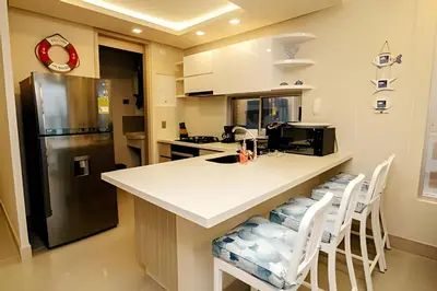 a kitchen with a counter and a refrigerator at Beachfront Bocagrande Stay | Breathtaking Sunsets in Cartagena de Indias
