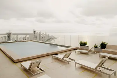 a room with chairs and a pool on a building at Beachfront Bocagrande Stay | Breathtaking Sunsets in Cartagena de Indias
