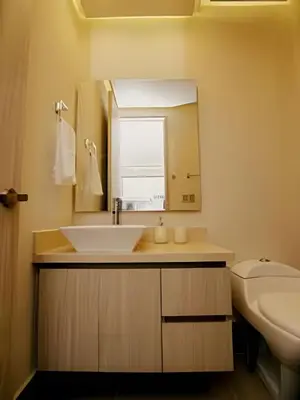 a bathroom with a sink and a mirror and a toilet at Beachfront Bocagrande Stay | Breathtaking Sunsets in Cartagena de Indias