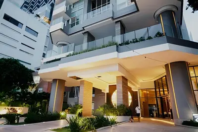 a building with a person walking in front of it at Beachfront Bocagrande Stay | Breathtaking Sunsets in Cartagena de Indias
