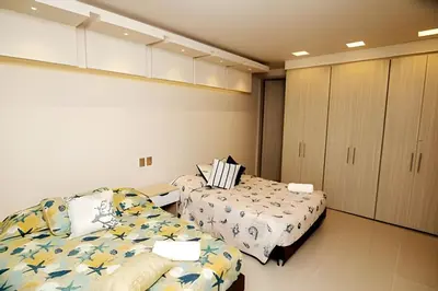 a room with two beds in a room with cabinets at Beachfront Bocagrande Stay | Breathtaking Sunsets in Cartagena de Indias