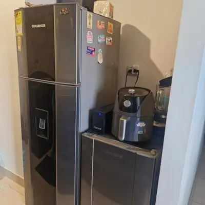 a refrigerator with magnets and a coffee maker on a counter at Apartmento en Parque Heredia in Cartagena de Indias