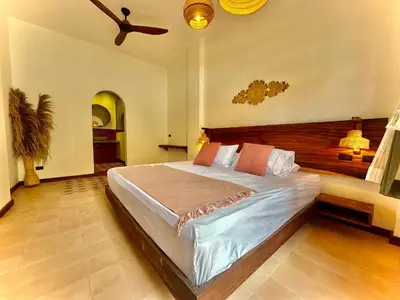 a bedroom with a large bed with a ceiling fan at Masaya Cartagena in Cartagena de Indias