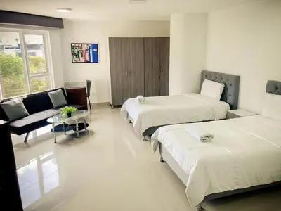 a hotel room with two beds and a couch at Lofts Mediterraneo in Barranquilla