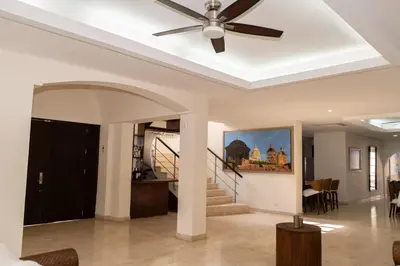 a ceiling fan in a living room with a staircase at Villa exclusiva junto al mar en Cartagena in Cartagena de Indias