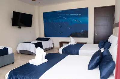 a hotel room with two beds and a flat screen tv at Villa exclusiva junto al mar en Cartagena in Cartagena de Indias