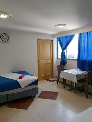 a bedroom with a bed and a desk and a window at Acogedor Apartaestudio Laguito 1 Habitacion N4A2 in Cartagena de Indias