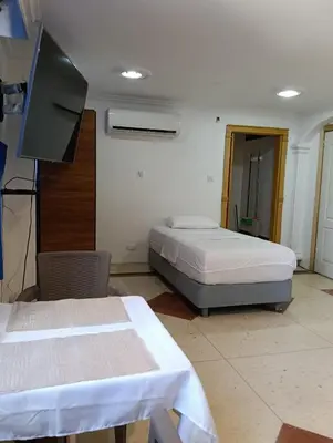 a room with two beds and a flat screen tv at Acogedor Apartaestudio Laguito 1 Habitacion N4A2 in Cartagena de Indias