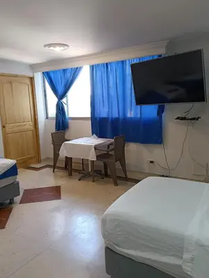 a room with a bedroom with a table and a tv at Acogedor Apartaestudio Laguito 1 Habitacion N4A2 in Cartagena de Indias