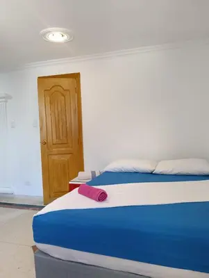 a bedroom with a bed with a red object on it at Acogedor Apartaestudio Laguito 1 Habitacion N4A2 in Cartagena de Indias