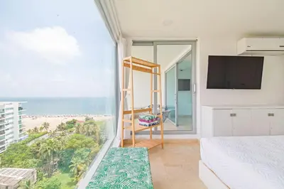 a bedroom with a bed and a view of the beach at Sonesta Resort Apartamento Morros Cartagena in Cartagena de Indias