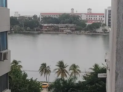 a large body of water with palm trees and buildings at Atardeceres del Laguito in Cartagena de Indias