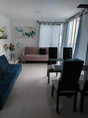 a living room with a couch and a table and chairs at Atardeceres del Laguito in Cartagena de Indias