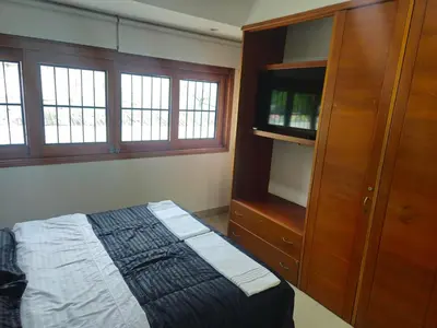 a bedroom with a bed and a wooden cabinet at Migo in Cartagena de Indias
