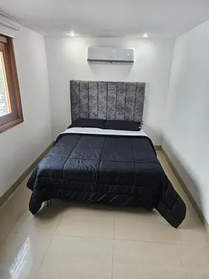 a bed in a bedroom with a black comforter at Migo in Cartagena de Indias