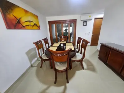 a dining room with a table and chairs and a painting at Migo in Cartagena de Indias