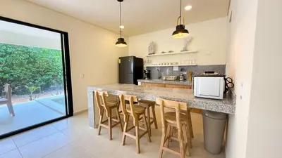 a kitchen with a large counter with stools at Cabaña Tierramia 3 in San Silvestre