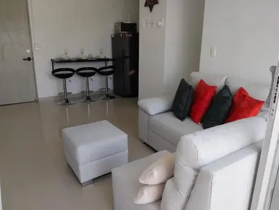 a living room with a white couch and red pillows at nice and affordable in Cartagena de Indias
