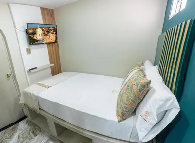a small room with a bed with a pillow at Sublime Hotel Cartagena in Cartagena de Indias