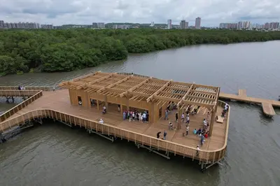 people standing on a wooden pier in the water at Apartamentos Palmar - Excelente Ubicación by SOHO in Barranquilla