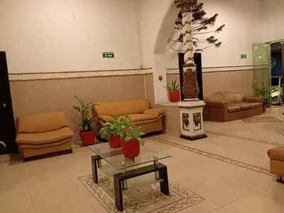 a living room with couches and a table and plants at Hotel Girasol Inn Barranquilla in Barranquilla