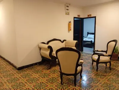 a room with chairs and a room with a bedroom at Hotel Girasol Inn Barranquilla in Barranquilla